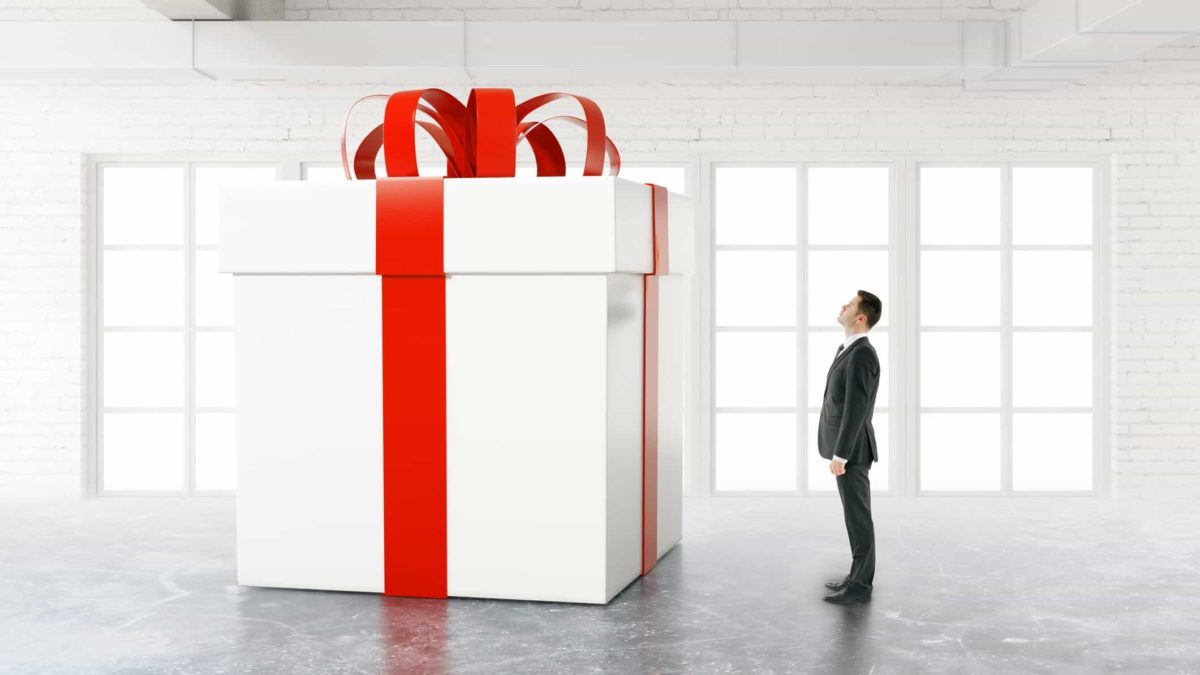 Surging asx share price represented by man looking up at giant gift