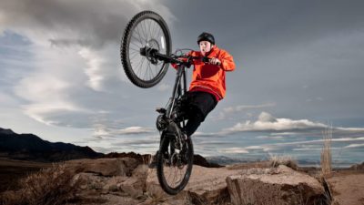 A man doing a wheelie on his bicycle, indicating a share price rise for ASX companies