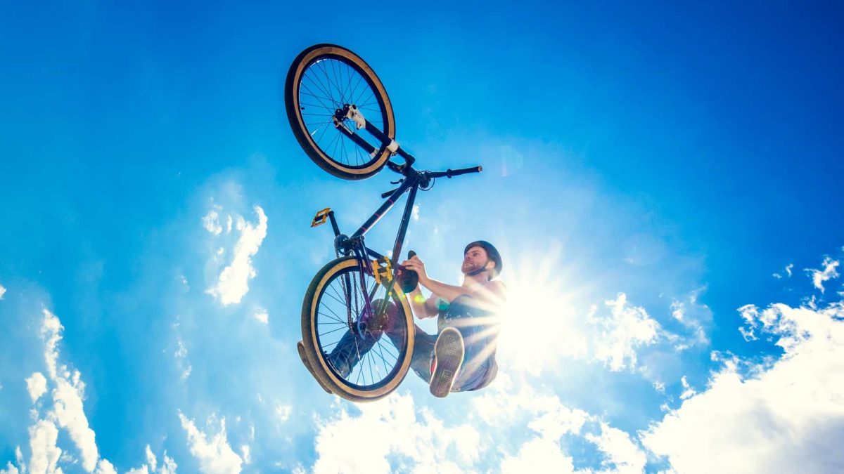 jump in asx share price represented by man on bike jumping high into the sky