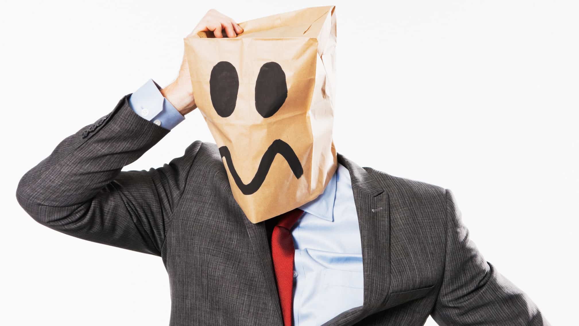 A business man with an idiot face drawn onto a paper bag on his head, indicating a company director using the 'honest idiot'defence
