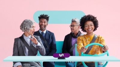 A group of four people riding a stylized car with lyft branding