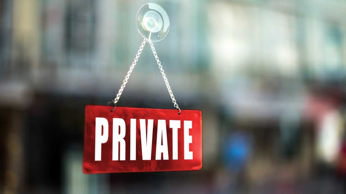 A sign saying private on a glass window