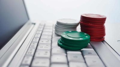 Tabcorp share price merger Poker chips on a laptop keyboard to symbolise gambling on ASX shares