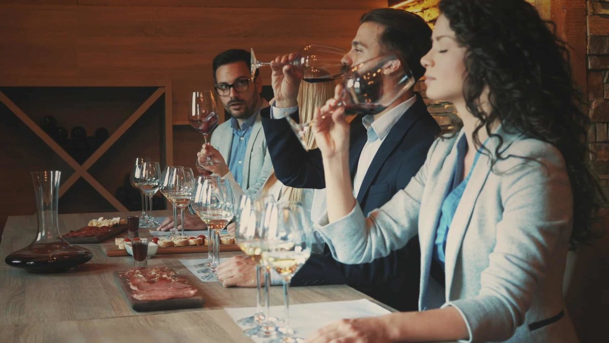 Woman and 2 men conducting a wine tasting