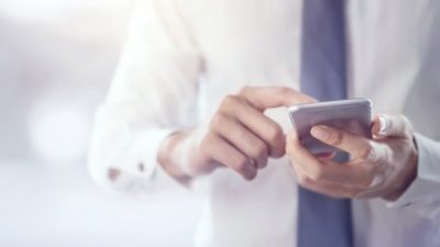 A businessman uses an app on his mobile phone