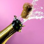 Cork popping out of wine bottle.