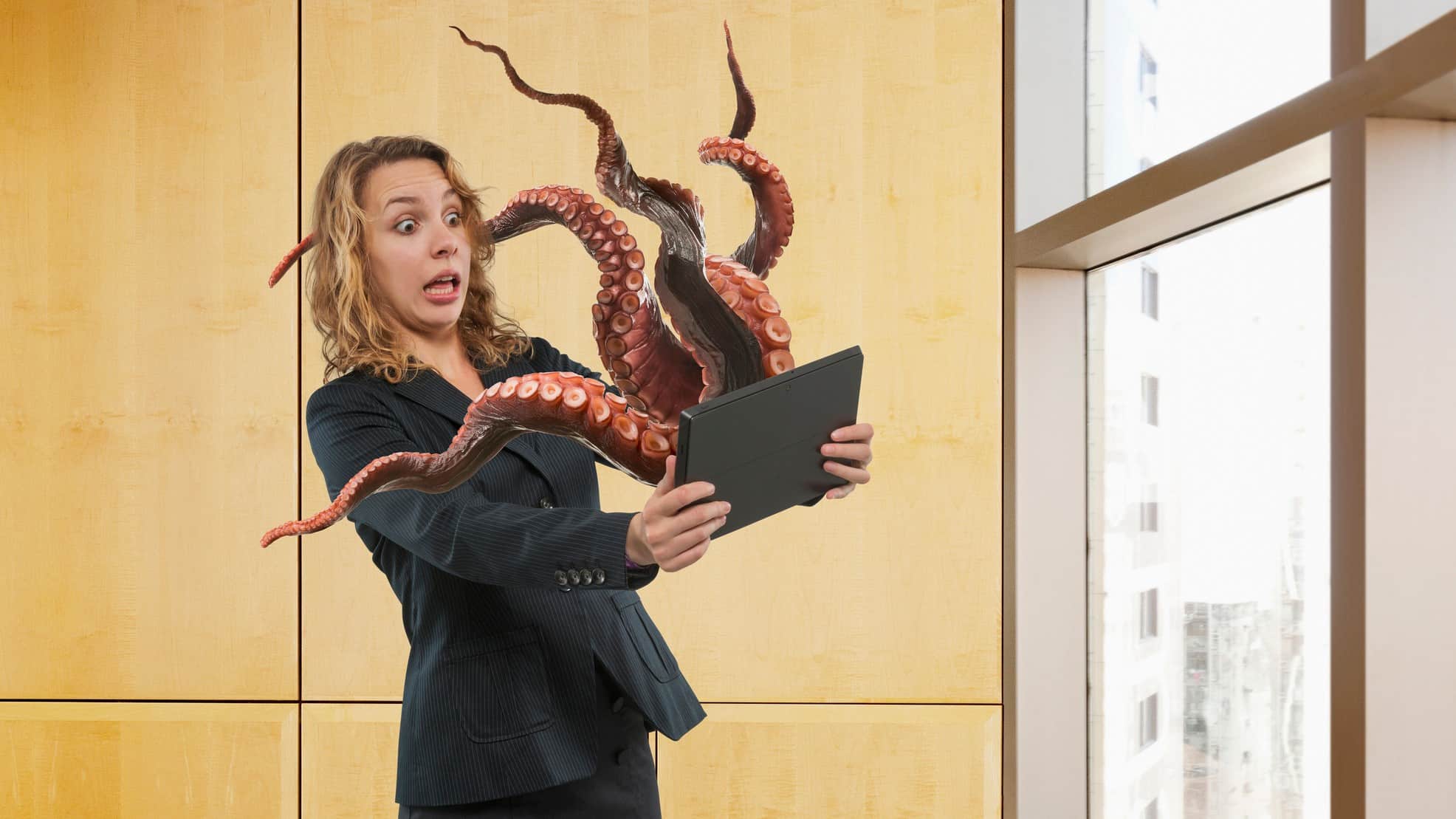 cybersecurity shares represented by octopus reaching out of computer screen towards woman
