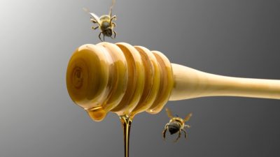 Bees buzz around a dripping honey pot, indicating attractive shares can sometimes be a value trap