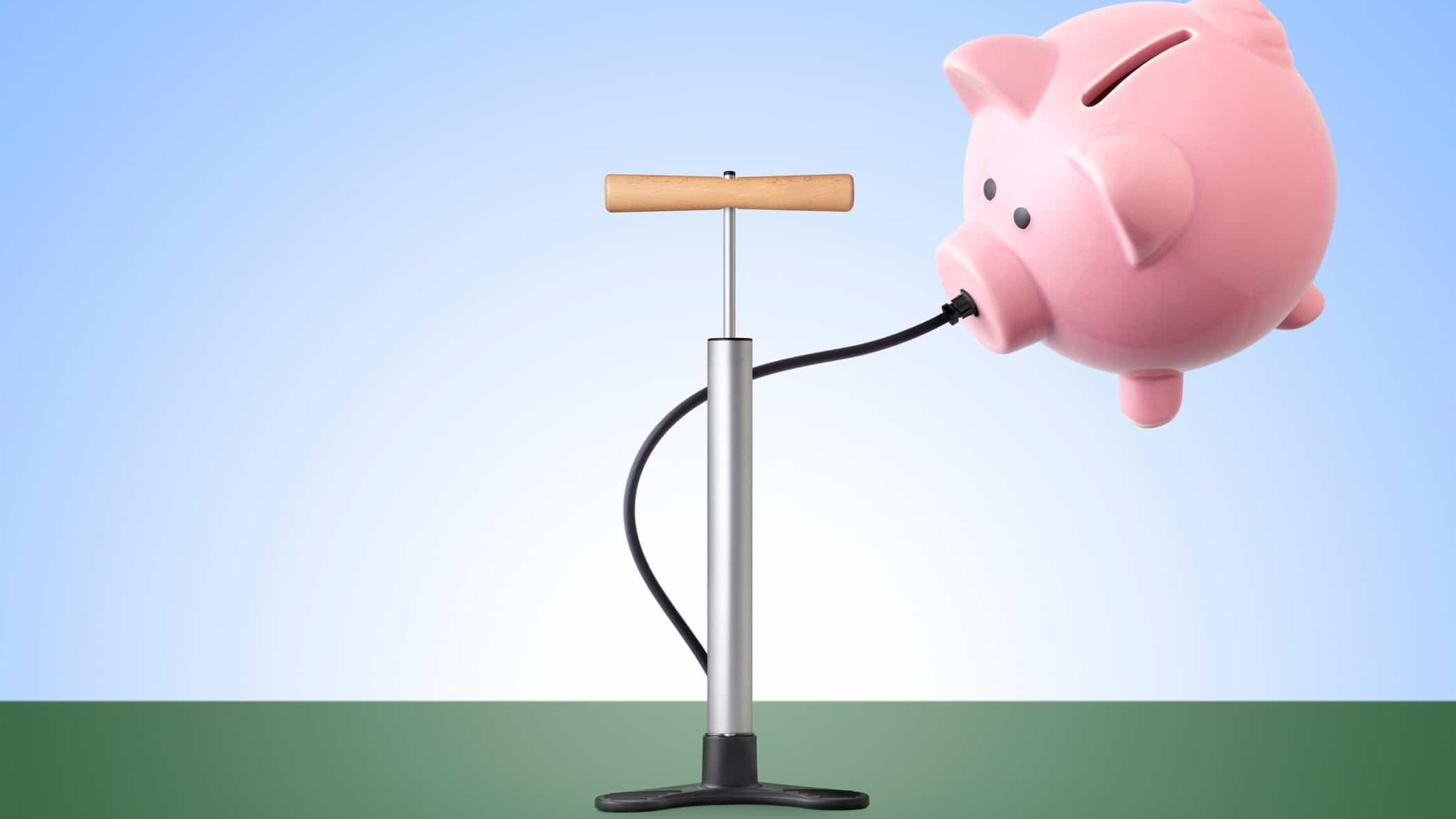 A piggy bank attached a bicycle pump floats up, indicating rising inflation