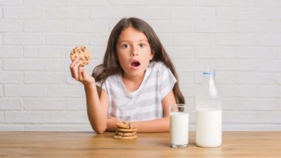 wide eyed girl next to glass of milk