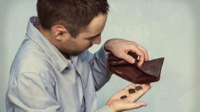 A man shuffles coins out of his empty wallet, indicating there is no shopping money left for retail shares