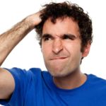 investor scratching head as if trying to decide whether to sell asx share price