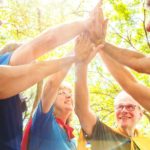 A group of people wearing capes join hands to celebrate, indicating a strong superannuation fund