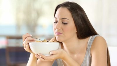 falling asx share price represented by sad looking lady eating bowl of cereal