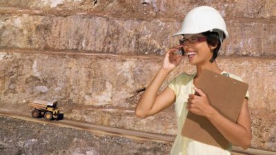 Female miner uses mobile phone at mine site