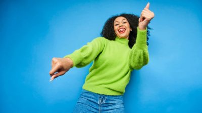 rising asx share price represented by happy woman dancing excitedly