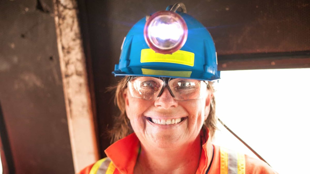 rising mining asx share price represented by happy woman miner in hard hat