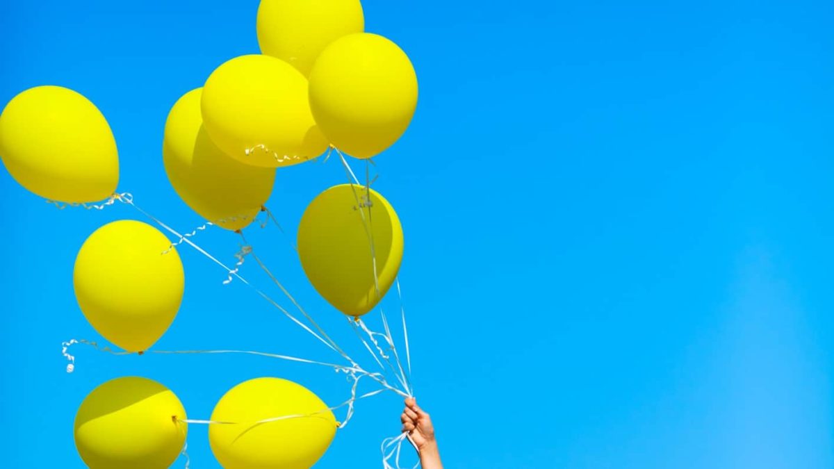 CBA share price represented by bunch of yellow balloons flying high