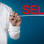 Business man marking Sell on board and underlining it