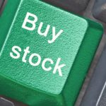 Green keyboard button saying buy stock.