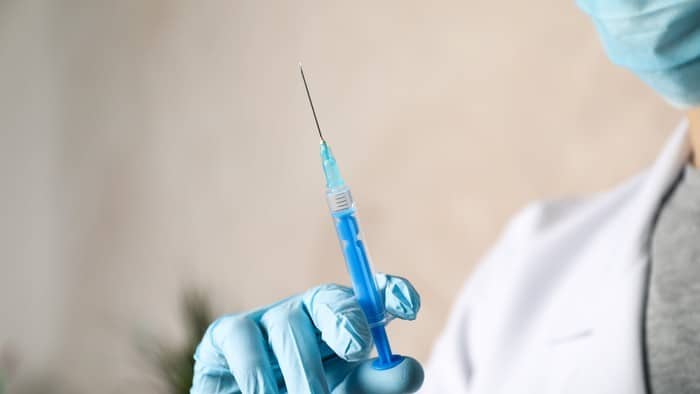 health worker holding a vaccine in their hand