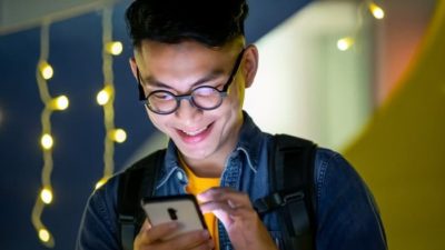 happy teenager using iPhone