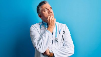 A doctor looks unsure, indicating share price uncertainty for ASX medical companies