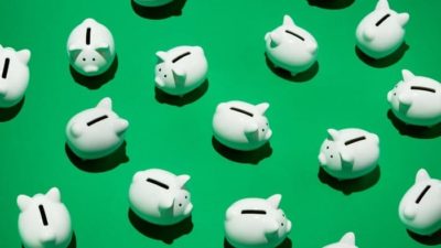green asx share price represented by lots of piggy banks in a green background