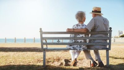 Two retirees sitting on a bench together.