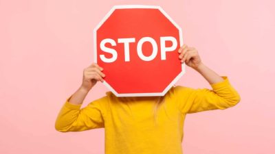 A person holds a stop sign in front of their head