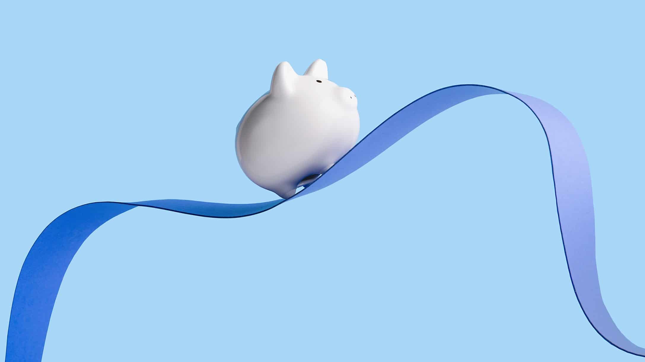 A piggy bank balances on a ribbon, indicating a wobbly share price
