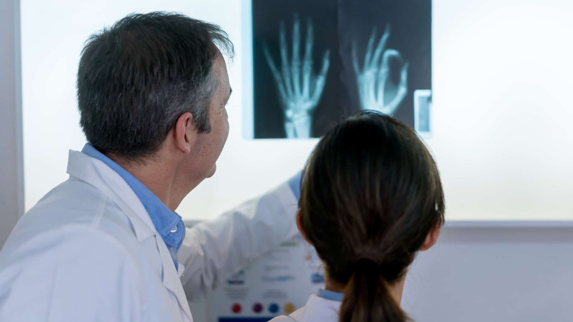 Medical specialist examine an xray of two hands, indicating share price movement in an ASX imaging company