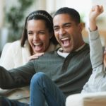 Family cheering in front of TV.