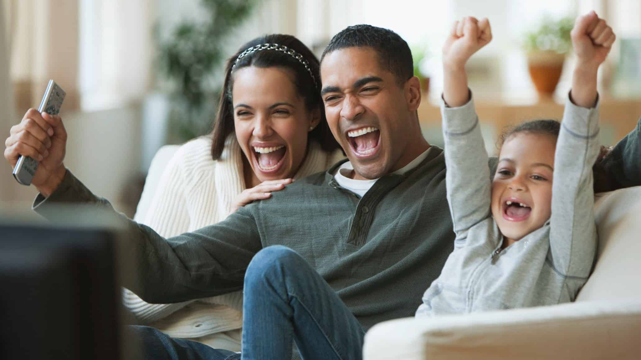 Family cheering in front of TV.