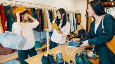 young people in fashion store considering shoes, hat, clothing