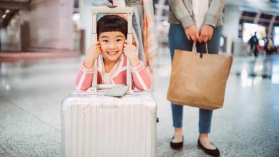 Happy girl with luggage at airport