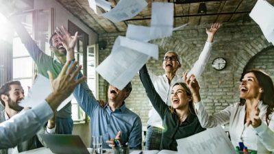 Happy office workers throw reports in the air