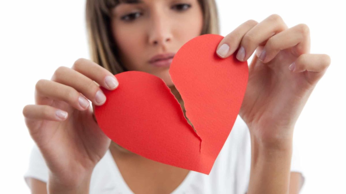 Girl tearing paper heart