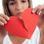 Girl tearing paper heart