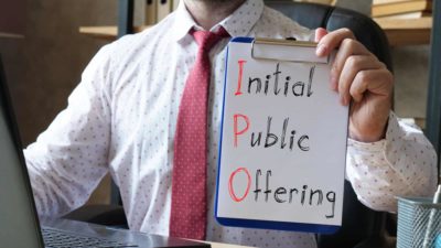 Initial Public Offering spelt out in writing with man holding a clipboard