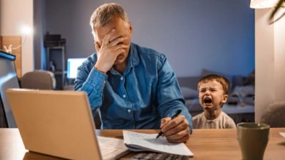 Man head in hands at computer as boy cries