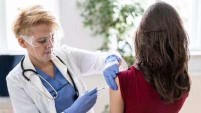 Female patient receives Pfizer covid vaccine administered by female doctor