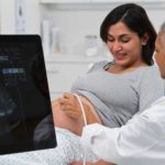 Doctor performing an ultrasound on pregnant woman