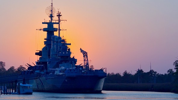navy ship sailing at dusk