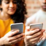 2 people using their iPhones