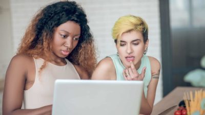 two women looking intently at computer screen