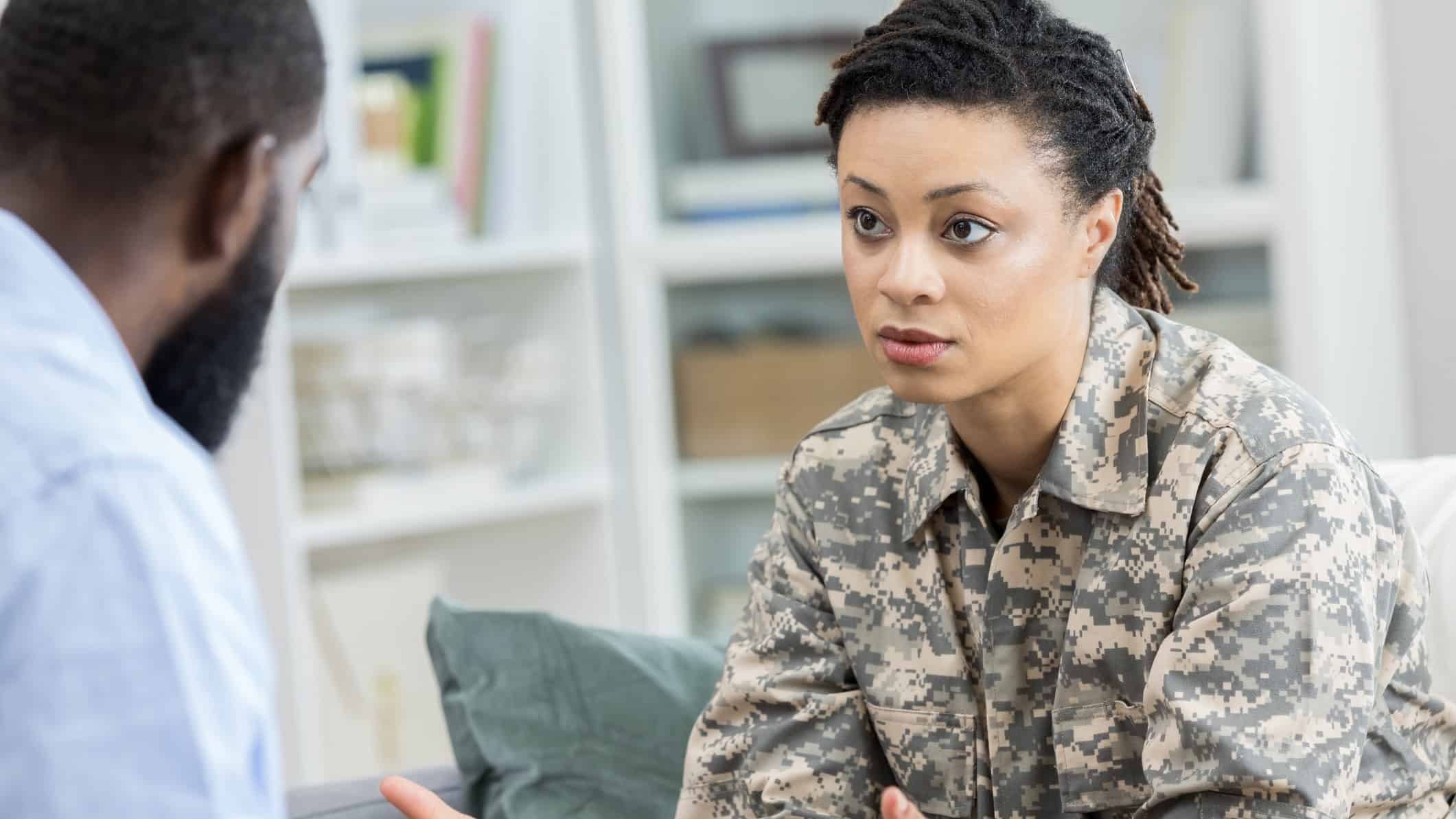 Army soldier looking sad and having conversation with her partner at home
