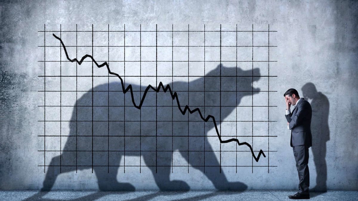A shadow bear faces a man against the backdrop of a falling share price.