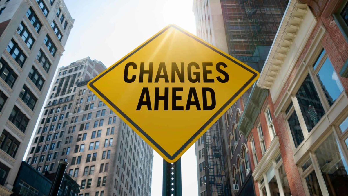 A yellow sign with the words 'Changes ahead' on a city backdrop, indicating volatile share price movement