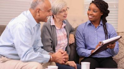 a woman explaining information to an elderly couple about finance